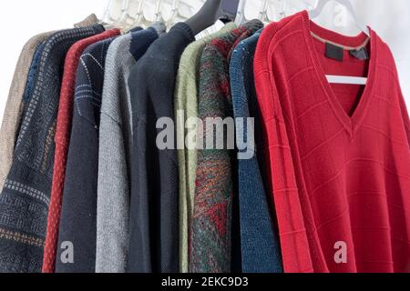 Horizontale Nahaufnahme von Herren-Pullovern an Kleiderbügeln. Stockfoto
