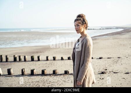 Junge Frau Tag träumen, während am Strand während des Wochenendes stehen Stockfoto