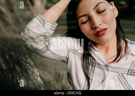 Schöne Frau mit geschlossenen Augen im öffentlichen Park Stockfoto
