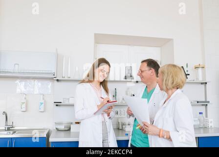 Wissenschaftler in weißen Mänteln arbeiten im Labor zusammen Stockfoto