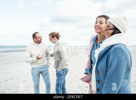 Gruppe von erwachsenen Freunden stehen und reden am Küstenstrand Stockfoto