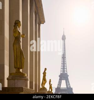 Frankreich, Ile-de-France, Paris, Goldene Statuen des Palais de Chaillot mit Eiffelturm im Hintergrund Stockfoto