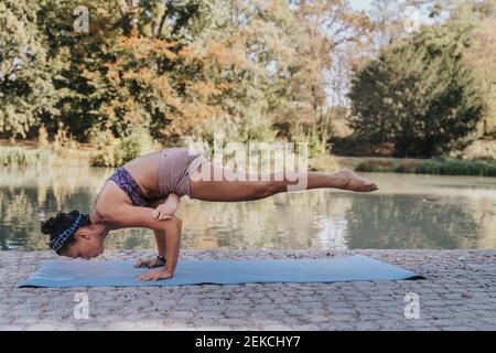 Reife Sportler balancieren beim Training Handstand Yoga auf Matte parken Stockfoto