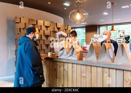 Eine Kollegin und eine Kollegin bereiten den Auftrag für den Kunden vor Im Restaurant während der COVID-19 Stockfoto