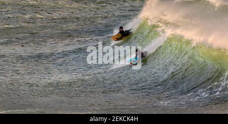 Freunde bodyboarding auf dem Meer in Broad Haven South Beach, Wales, Großbritannien Stockfoto