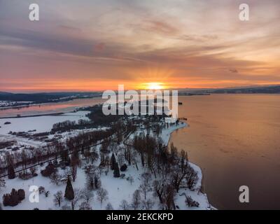 Deutschland, Baden-Württemberg, Radolfzell, Luftaufnahme der schneebedeckten Halbinsel Mettnau bei Sonnenuntergang Stockfoto