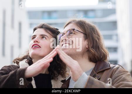 Glückliches Paar, das mit Händen Hausform macht Stockfoto