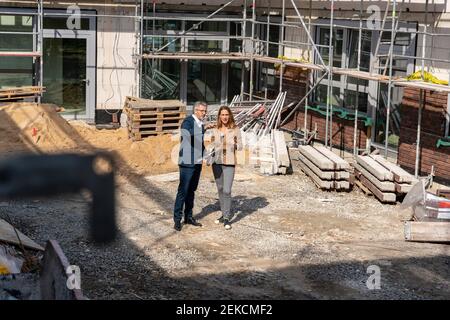 Ingenieur, der auf der Baustelle mit einem Kollegen diskutiert Stockfoto