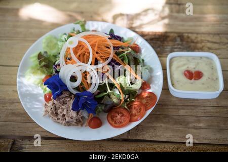 Frühstückssalat und Orangensaft mit orangefarbenem Holzhintergrund Stockfoto