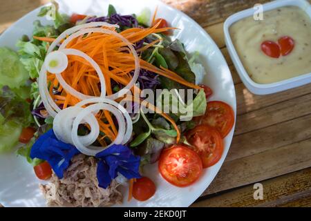 Frühstückssalat und Orangensaft mit orangefarbenem Holzhintergrund Stockfoto