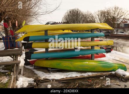 Kanus und Paddel liegen im Winter am Ufer Die Frostperiode in den niederlanden Stockfoto