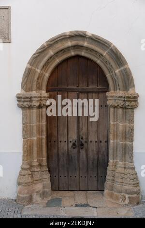 Mittelalterliche Holztür mit Marmorrahmen einer Kirche in Arraiolos, Portugal Stockfoto