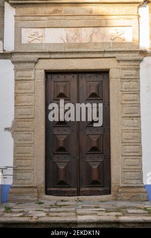 Mittelalterliche Holztür mit Marmorrahmen einer Kirche in Arraiolos, Portugal Stockfoto