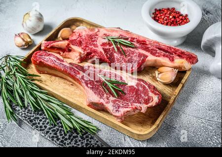 Rohe Fleischstücke aus Rindermarmor auf den Knochen. Weißer Hintergrund. Draufsicht Stockfoto