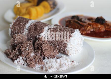 Gedämpfte Fingerhirse und Kokosnusskuchen, serviert mit Sardinen-Curry und gedämpfter Kochbanane. Schuss auf weißem Untergrund Stockfoto