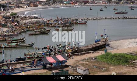 Cape Coast Ghana Fischerdorf Afrika. Alte handgemachte Fischerboote fischen im Ocean Bay Marina Dorf. Schlechte Hygiene und Armut. Stockfoto