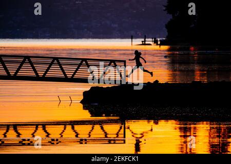 Silhouette des Läufers an der Port Blakely Bridge bei Sonnenaufgang, Bainbridge Island, Washington, USA Stockfoto