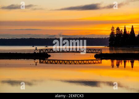 Silhouette des Läufers an der Port Blakely Bridge bei Sonnenaufgang, Bainbridge Island, Washington, USA Stockfoto