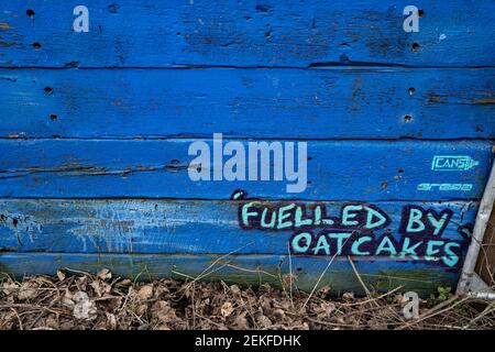 Graffiti auf einem Zaun am Trent und Mersey Kanal, Middleport, Stoke-on-Trent, Großbritannien, sagen "angeheizt von Haferkuchen" ein lokales Essen der Gegend. Stockfoto