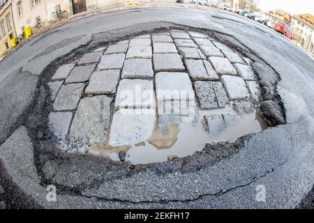 Leipzig, Deutschland. Februar 2021, 19th. Das Wasser sammelt sich während des Tauens in einem frischen Schlagloch. Wie in jedem Winter sind die Straßen besonders durch den Wechsel von Frost und Tauwetter betroffen. Quelle: Jan Woitas/dpa-Zentralbild/ZB/dpa/Alamy Live News Stockfoto