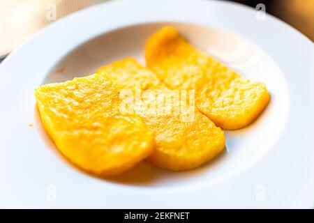 Polenta leuchtend gelb orange Maiskuchen gebraten über Ansicht auf Weiße Platte im Restaurant Vorspeise goldene Farbe Stockfoto