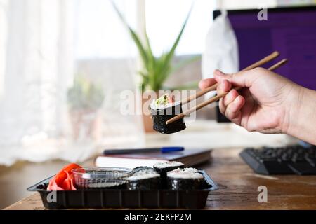 Sushi zu Hause aus Plastikbox essen, im Lifestyle. Stockfoto