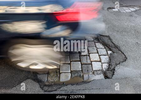 Leipzig, Deutschland. Februar 2021, 19th. Ein Auto fährt über eine Straße mit Schlaglöchern. Wie in jedem Winter sind die Straßen besonders durch den Wechsel von Frost und Tauwetter betroffen. Quelle: Jan Woitas/dpa-Zentralbild/ZB/dpa/Alamy Live News Stockfoto