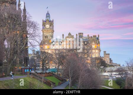 Nächtliches Stadtbild in Edinburgh, Schottland mit farbenfrohem Sonnenuntergang oder Sonnenaufgangshimmel über dem Balmoral Clock Tower, neben den Princes Street Gardens und über W Stockfoto