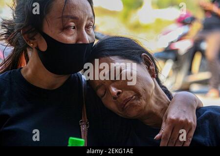 Ein Verwandter tröstet Thidar Hnin (R), als sie während der Trauerfeier ihren Mann Thet Naing Win trauert. Tausende versammeln sich auf dem Friedhof von Kyarnikan in Mandalay zur Beerdigung von Thet Naing Win wurde am Samstag während der Putschproteste von myanmarischen Sicherheitskräften erschossen. Stockfoto