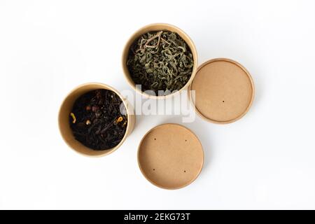 Grüner und schwarzer Tee in wiederverwendbarer runder Kartonverpackung isoliert auf weißem Hintergrund. Blick von oben. Stockfoto