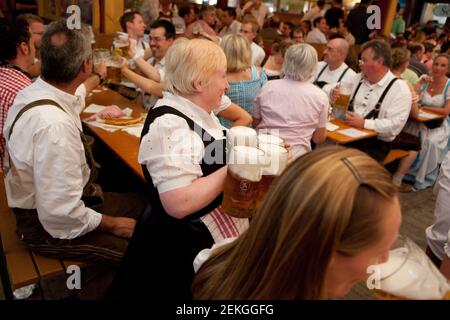 Deutschland Münchner Kellnerin trägt große Liter große Bierbecher bei Oktoberfest auf der Theresienwiese in München Stockfoto