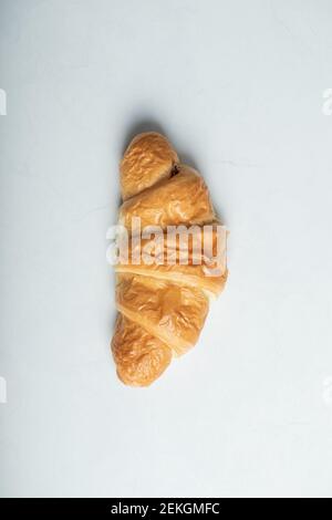 Ein ganzes frisches leckeres Croissant auf weißem Hintergrund Stockfoto