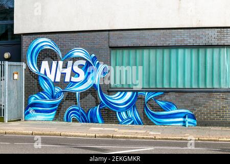 NHS-Logo in einem herzförmigen Band Wandbild in East London, Großbritannien Stockfoto