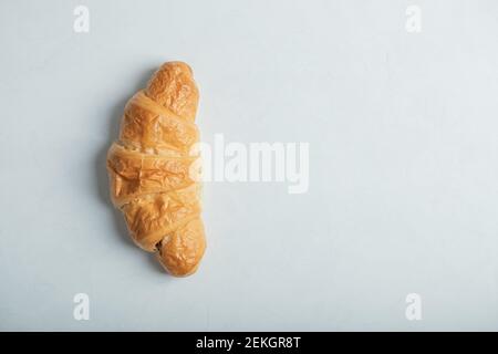 Ein ganzes frisches leckeres Croissant auf weißem Hintergrund Stockfoto