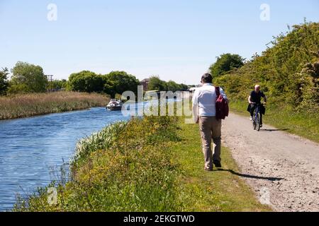 Forth und Clyde Canal bei Falkirk mit Menschen auf dem Schlepptweg und einem kleinen Boot. Stockfoto