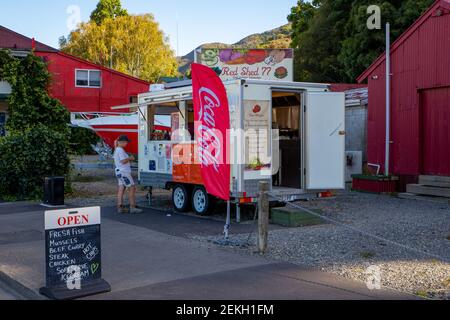 Havelock, Marlborough, Neuseeland, Februar 19 2021: Red Shed 77 - ein Food-Van, der frischen Fisch, Muscheln, Curry, Getränke, Eis auf der Hauptstraße verkauft Stockfoto