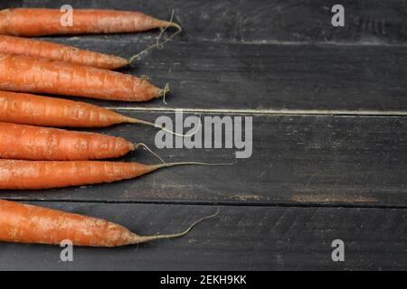 Frische Karotten Haufen auf Holz Hintergrund mit Platz für Text.Creative Vorlage Garten Ernährung, gesundes Gemüse Lebensmittel Konzept Stockfoto