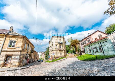 Lviv, Ukraine - 1. August 2018: Steile Straße auf Zamkova Straße mit Kopfsteinpflaster in der historischen ukrainischen Stadt Lvov während des Tages mit alten Vintage-Gebäude in Stockfoto