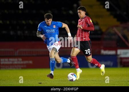 Brennan Johnson (rechts) von Lincoln City und Tom Broadbent von Swindon Town kämpfen während des Sky Bet League One-Spiels im LNER Stadium in Lincoln um den Ball. Bilddatum: Dienstag, 23. Februar 2021. Stockfoto