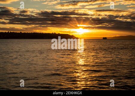 WA19338-00...WASHINGTON - Sonnenuntergang über der Elliot Bay und der Seattle Bremerton Fähre vom Pier 62 an der Seattle Waterfront aus gesehen. Stockfoto