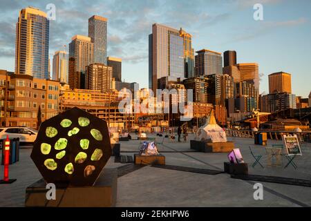 WA19341-00...WASHINGTON - Pier 62 mit einer Reihe von Bürohochhäusern hinter dem Sonnenuntergang an der Seattle Waterfront. 2021 Stockfoto