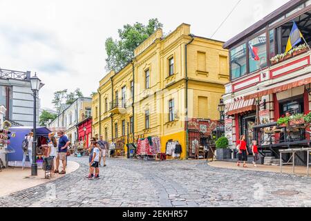Kiew, Ukraine - 12. August 2018: Alte historische Stadt Kiew gelbe Gebäude im Sommer und Menschen zu Fuß auf Andriyivskyi uzviz Abstieg während des Tages Stockfoto