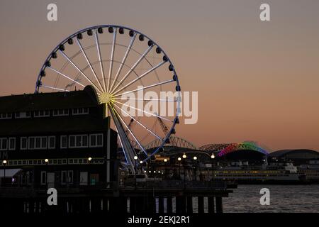 WA19348-00...WASHINGTON - Seattle Uferpromenade direkt nach dem Sonnenuntergang mit dem Seattle Aquarium, dem Great Wheel. 2021 Stockfoto