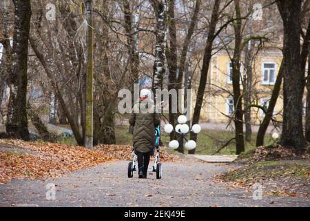 4. November 2018 - Beschetsk, Russland: Die Frau geht mit dem Kinderwagen am trüben Herbsttag Stockfoto