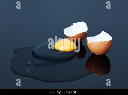 Zerbrochene Hühnereier auf schwarzem Hintergrund aus nächster Nähe Stockfoto