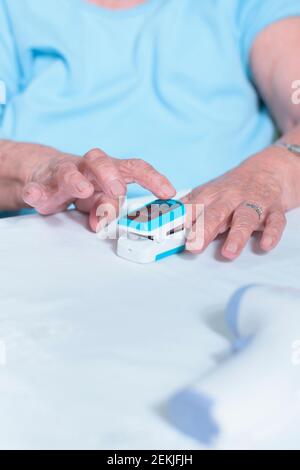 Großmutter zeigt, wie man das Oximeter benutzt Stockfoto