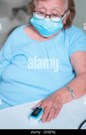 Großmutter zeigt, wie man das Oximeter benutzt Stockfoto