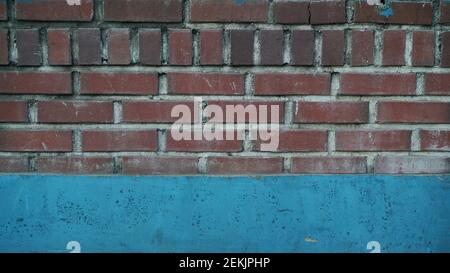 Red Brick Wall unten gemalt blau auf der Straße Stockfoto