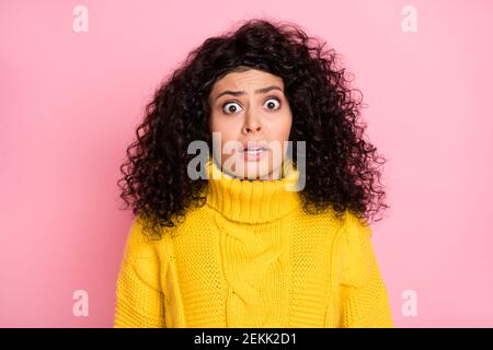 Foto-Porträt von erstaunt frustriert gestresst lockig Mädchen in gestrickt Pullover isoliert auf pastellrosa Hintergrund Stockfoto