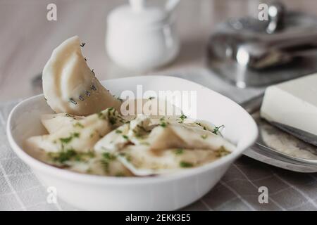 Knödel, gefüllt mit Kartoffeln und serviert mit Butter und Fenchel. Varenyky, vareniki, pierogi, pyrohy. Knödel mit Füllung. Stockfoto